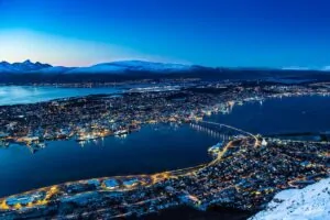 Tromsø kivilágított városképe télen, kék órában, magasból